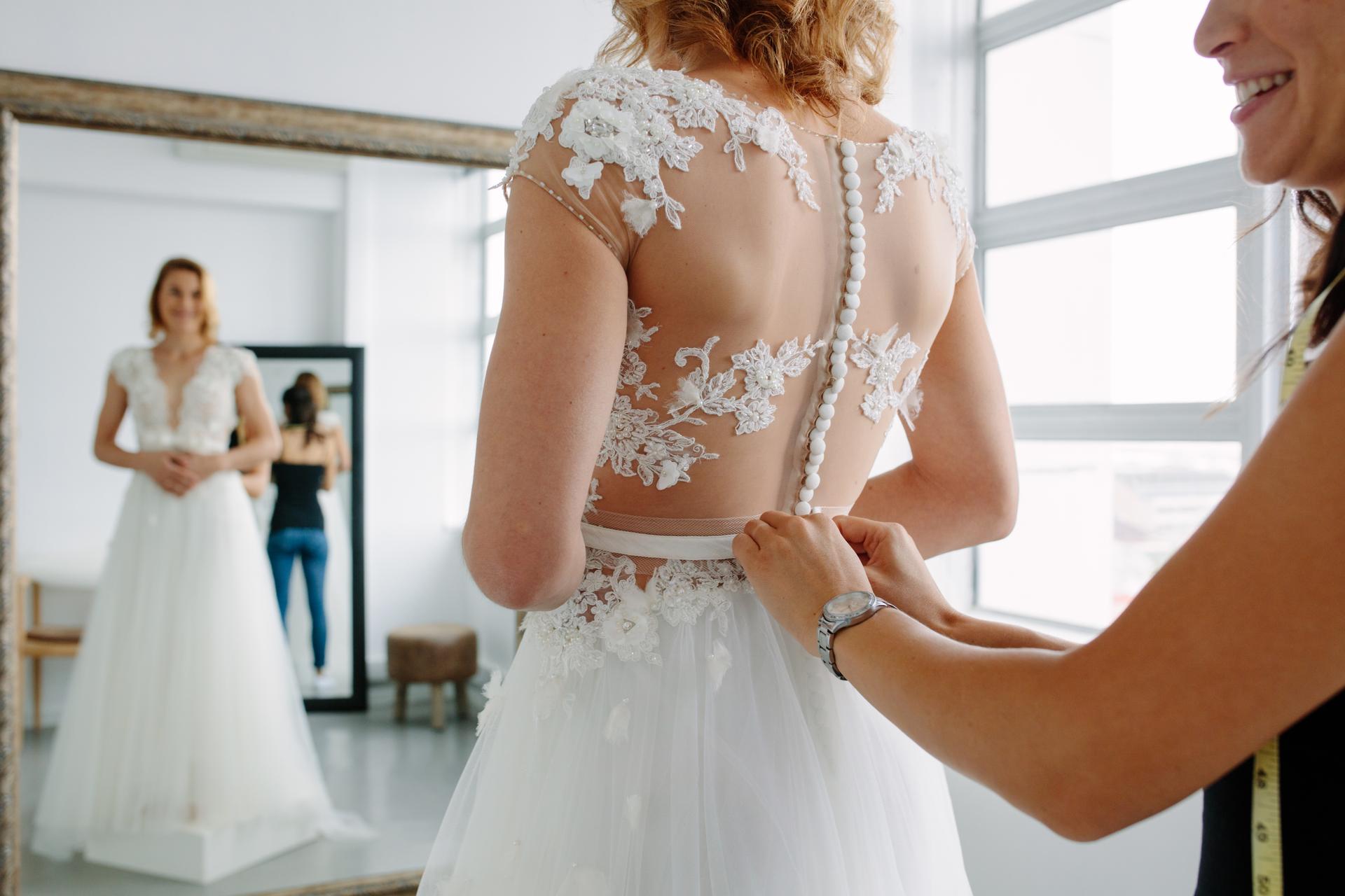 Making final touch on tailor made gown in bridal shop